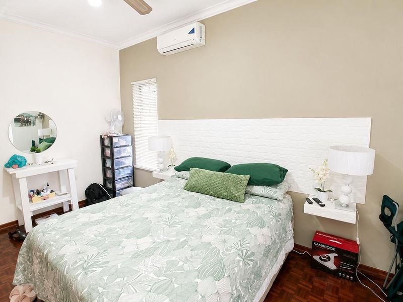A bedroom featuring timber parquet flooring, a split-system air conditioner, ceiling fan, and wall-mounted bedside shelves.