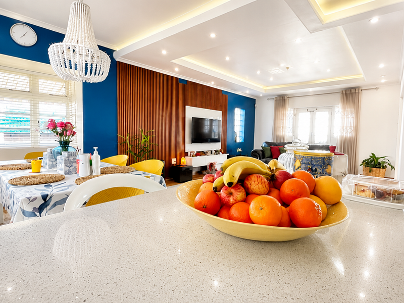 Spacious open-plan living and dining area featuring a modern quartz kitchen island, timber slat feature wall, and elegant recessed ceiling lighting.
