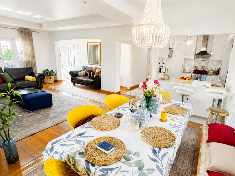 Spacious open-plan living and dining area featuring hardwood floors, a modern kitchen with island, and abundant natural light through french doors.