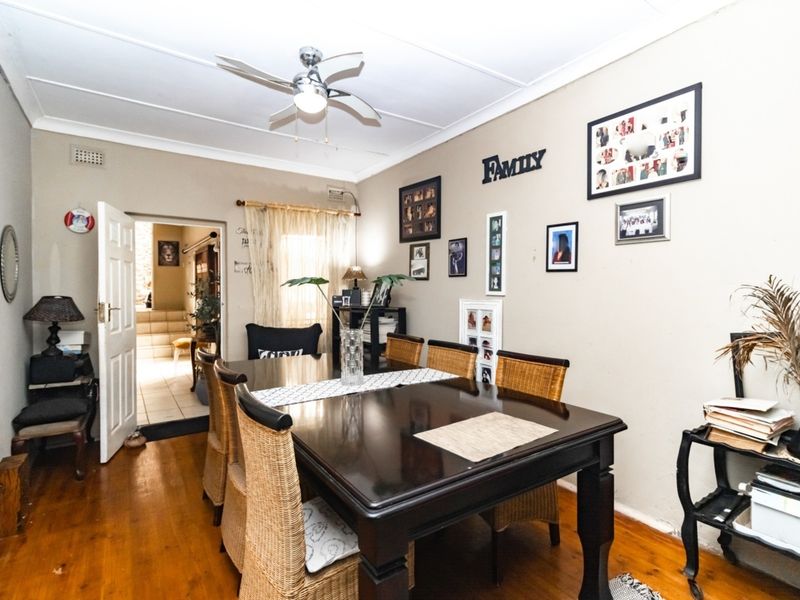 Dining room featuring hardwood flooring, a ceiling fan, and coved ceilings, providing a functional space for family meals.