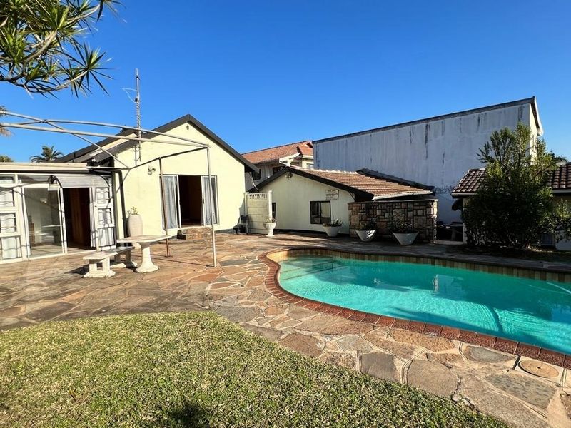 Outdoor pool area featuring a stone-paved patio, swimming pool, and direct access to the home through sliding glass doors.
