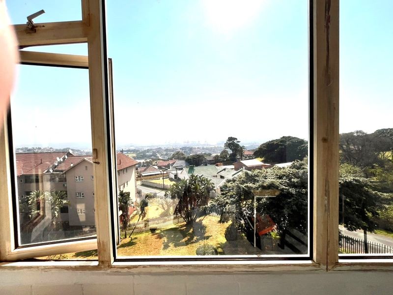 A view from an apartment window overlooking the surrounding neighborhood and landscape.