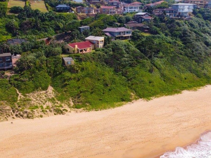 An aerial view of the coastal property, showcasing its prime beachfront location and elevated position along the coastline.