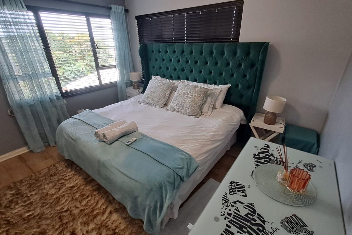 A well-maintained bedroom featuring laminate flooring and window blinds, offering a comfortable and functional living space.