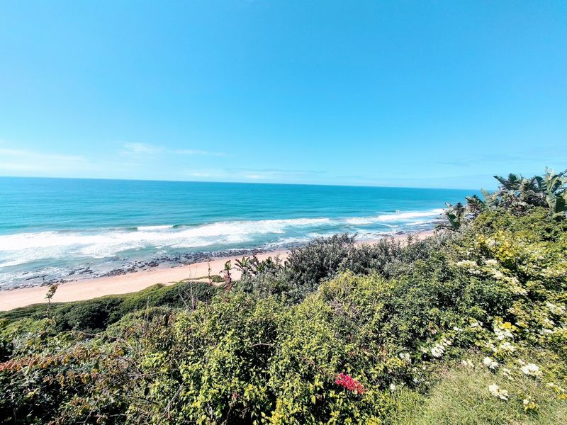A scenic elevated view overlooking the coastline, sandy beach, and ocean waves.