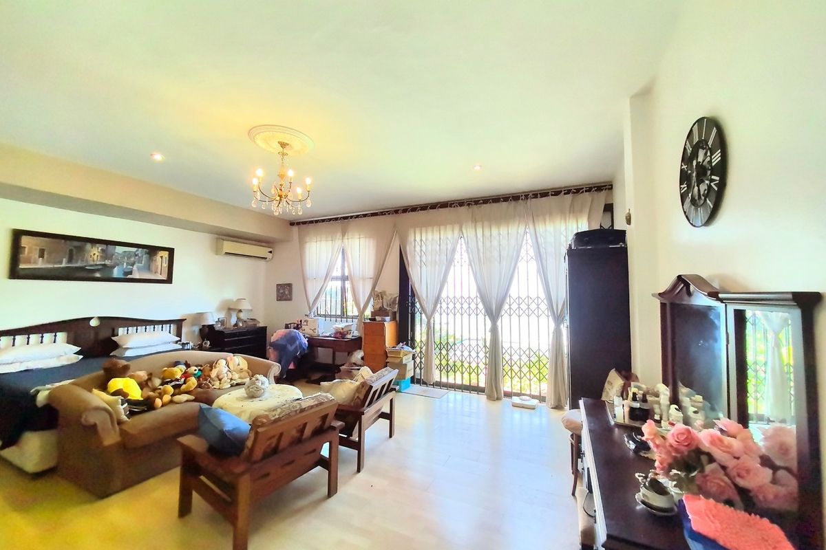Spacious bedroom featuring light-toned flooring, recessed lighting, a decorative ceiling rose, and direct access to an outdoor area through a security gate.