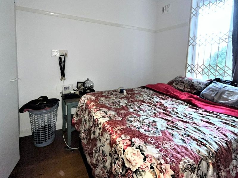 A bedroom featuring a built-in wardrobe, security gate on the window, and picture rail detailing.