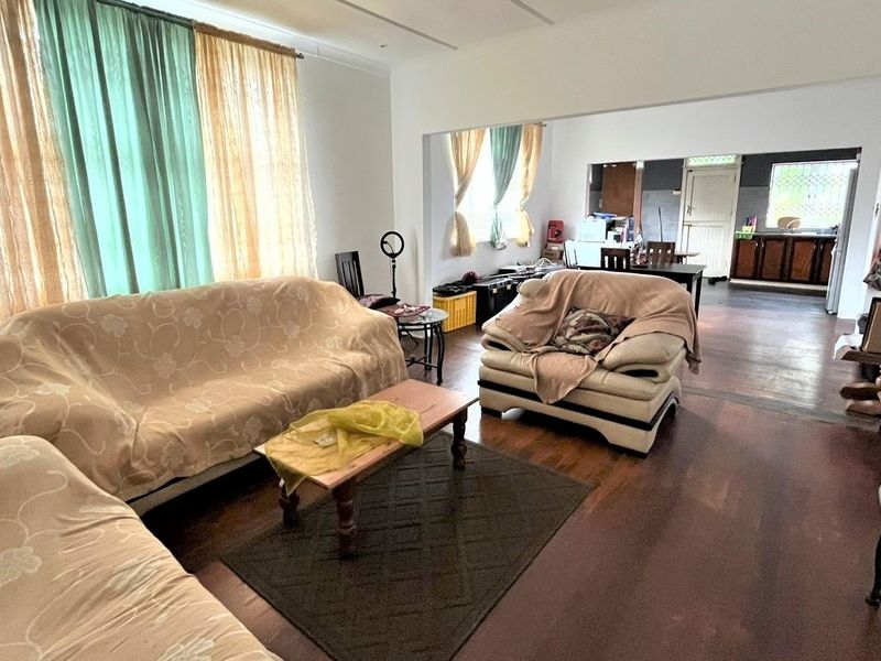 Open plan living and dining area featuring hardwood flooring and a connected kitchen space with built-in cabinetry.