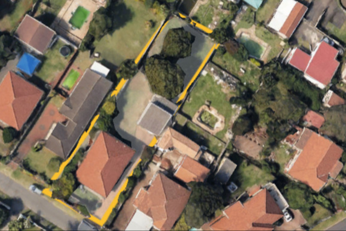 An aerial view of the property showing the building footprint, roof structure, and surrounding garden area within the plot boundaries.