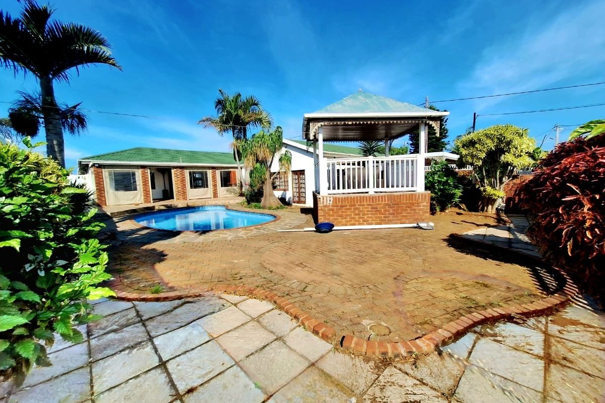 Outdoor entertainment area featuring a swimming pool, brick paved patio, and a covered gazebo structure in a landscaped garden setting.