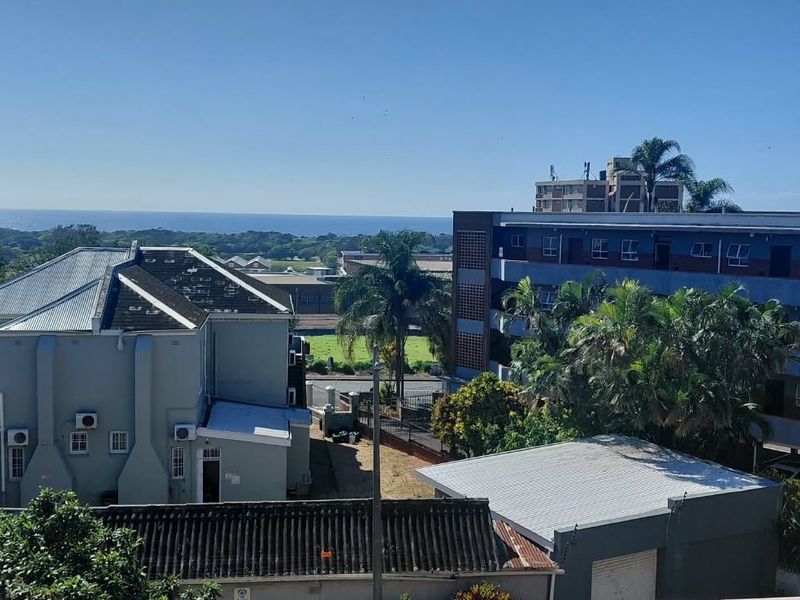 An elevated view overlooking the surrounding neighborhood with a distant ocean horizon.
