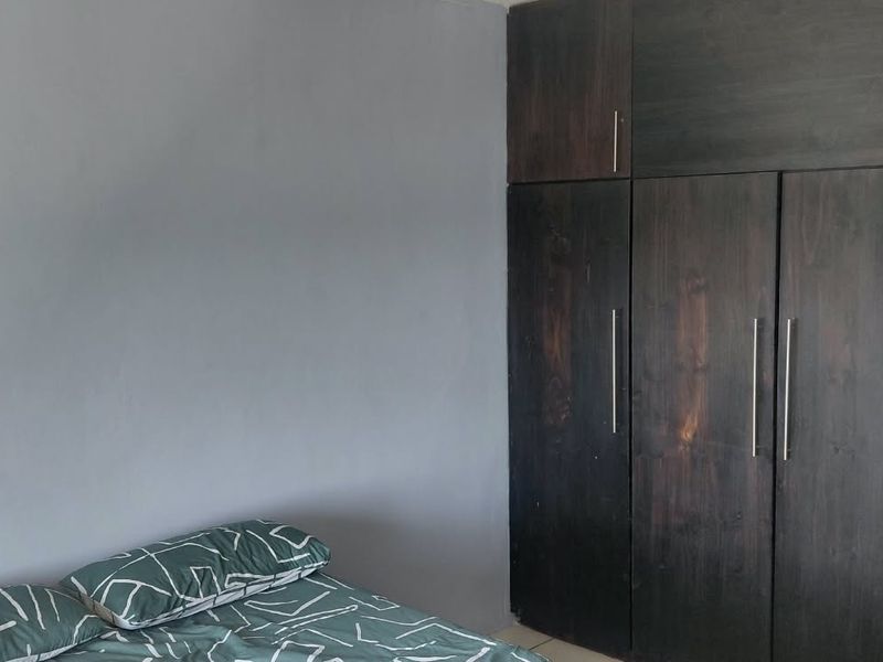 A bedroom featuring dark wood built-in cupboards providing ample storage space.