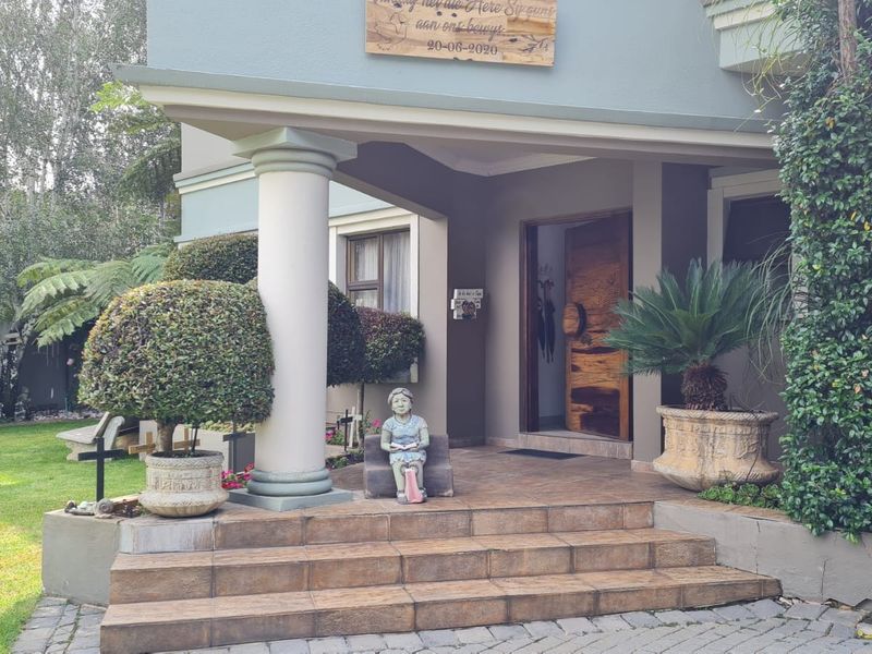 Inviting front entrance featuring tiled steps, a covered porch with a structural column, and a solid wood front door.