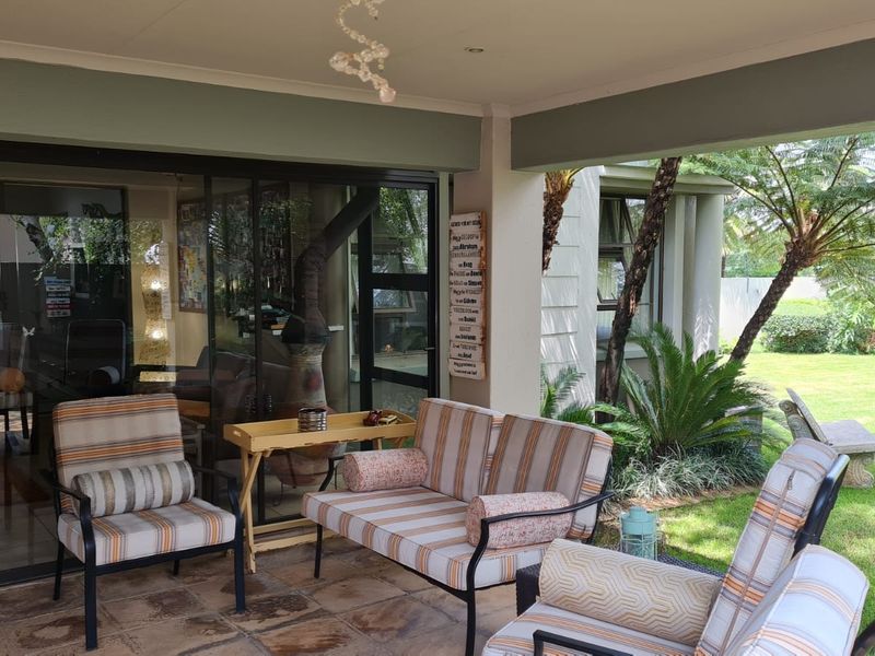 A covered outdoor patio area featuring tiled flooring and large sliding glass doors that provide access to the interior living space.