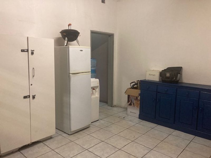 A functional utility space featuring tiled flooring and built-in storage cabinetry, suitable for storage or laundry purposes.