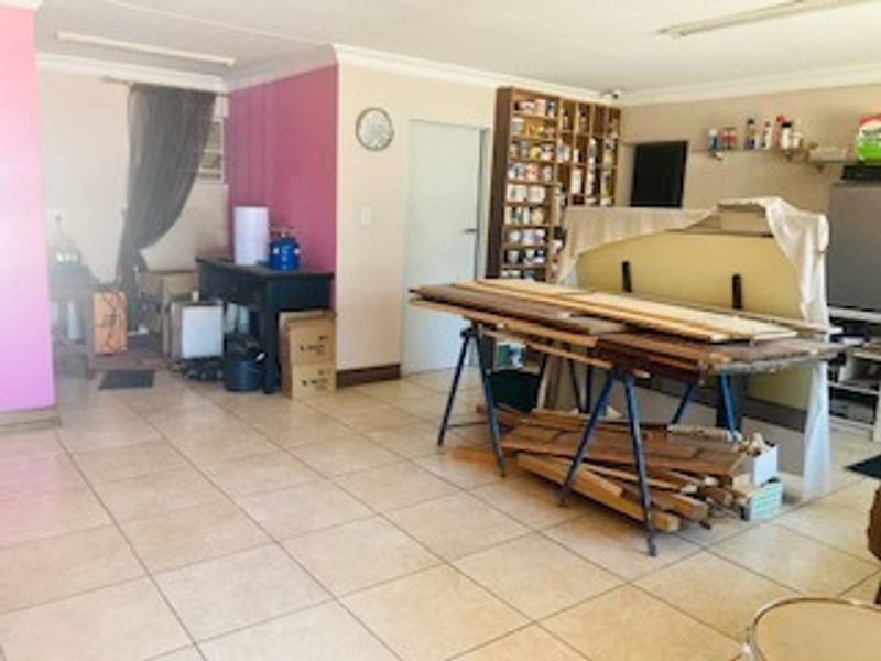 A spacious garage area featuring tiled flooring and built-in shelving, suitable for vehicle storage or as a functional workshop space.