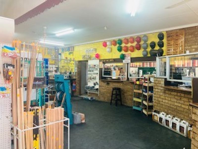 Interior view of a commercial utility or retail space featuring exposed brick walls, service counter, and functional overhead lighting.