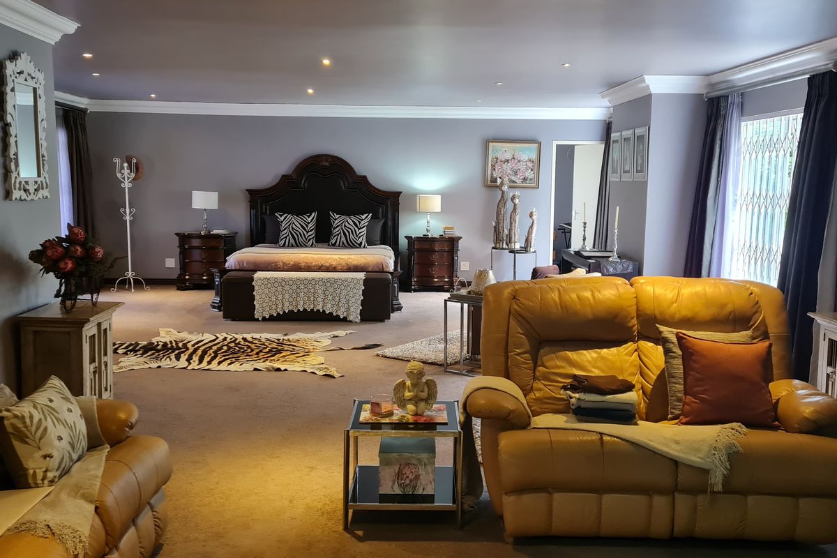 Spacious primary bedroom suite featuring recessed ceiling lighting, crown molding, and large windows with security gates.