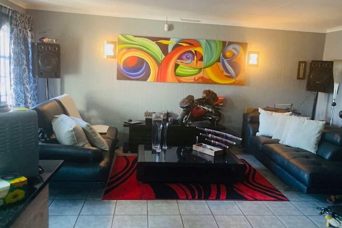 A living room featuring tiled flooring and wall-mounted lighting fixtures.