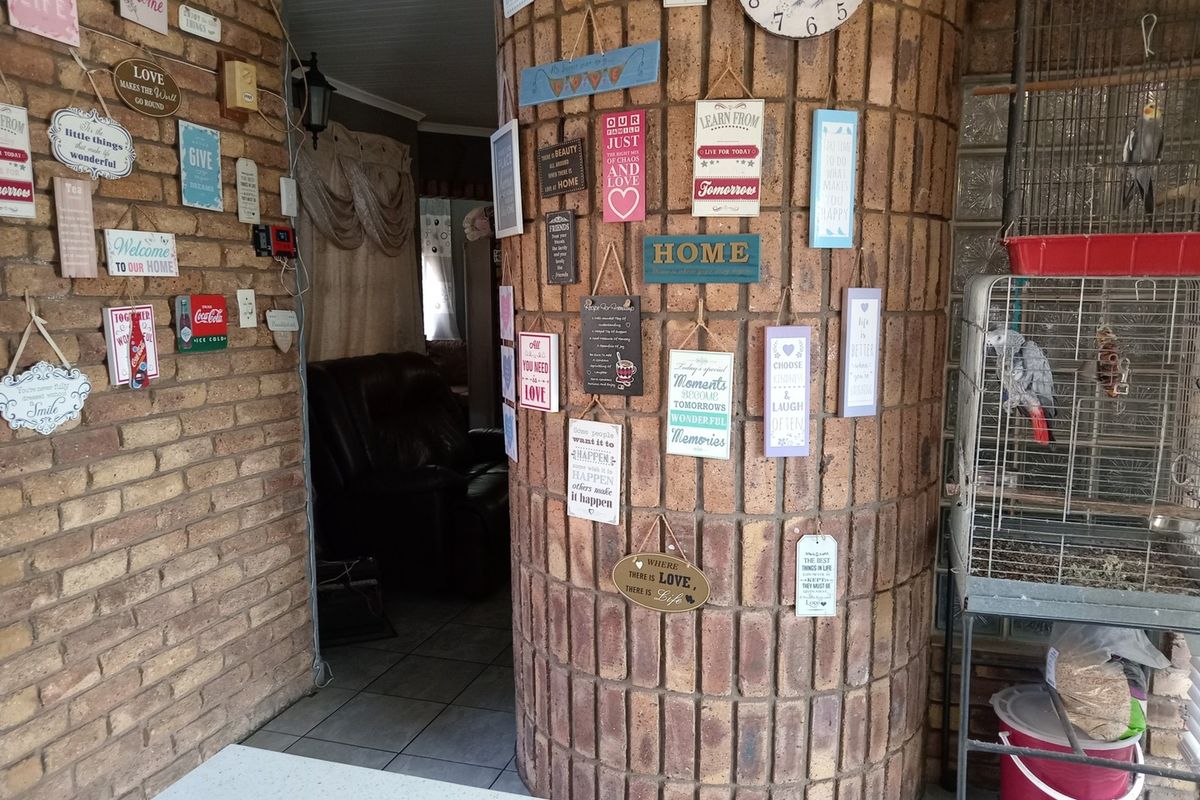 An interior view featuring a distinctive curved brick feature wall and tiled flooring, leading into an adjacent living space.