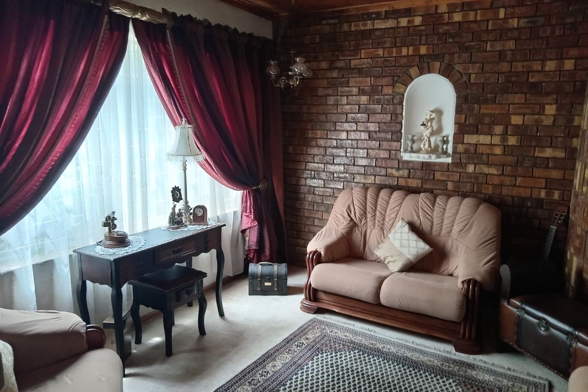 A living room featuring a rustic exposed brick wall with a built-in niche and a warm timber-paneled ceiling.