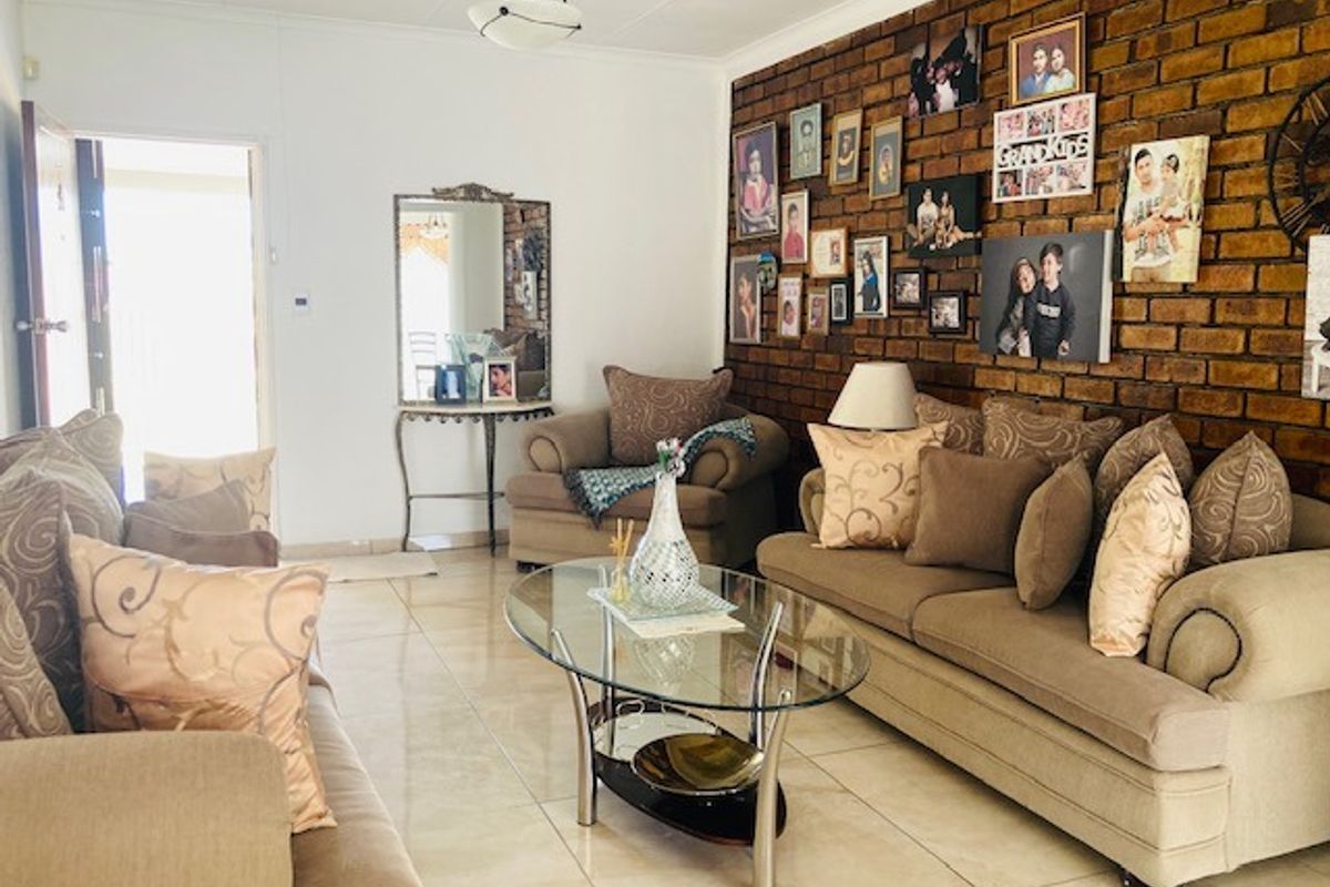 A living room featuring a prominent exposed brick feature wall and polished tile flooring, providing a warm and textured aesthetic.