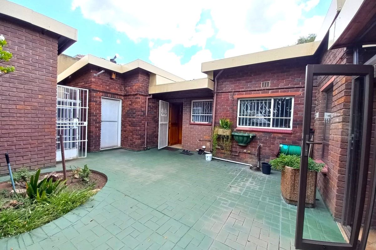A private rear courtyard featuring brick construction, paved flooring, and secure access points, offering a functional outdoor space for the property.