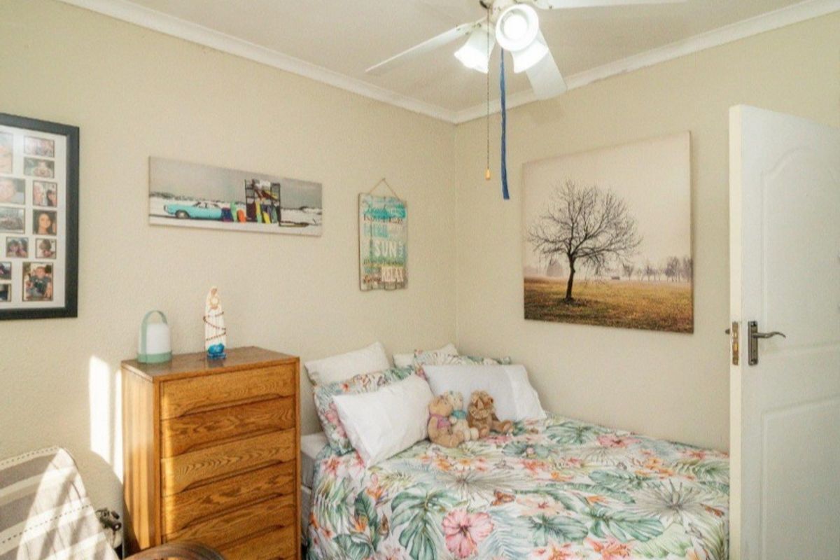 A standard bedroom featuring a ceiling fan and neutral wall finishes.