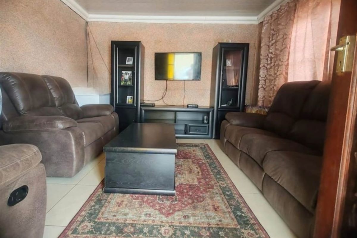 A living room featuring tiled flooring and coved ceilings, presenting an opportunity for cosmetic updates to modernize the space.
