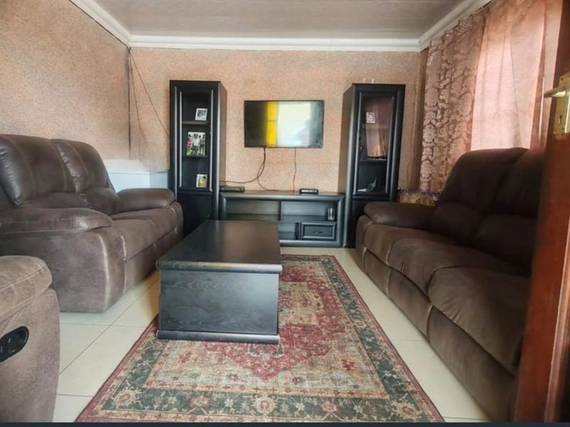 A living room featuring tiled flooring and coved ceilings, presenting an opportunity for cosmetic updates to modernize the space.