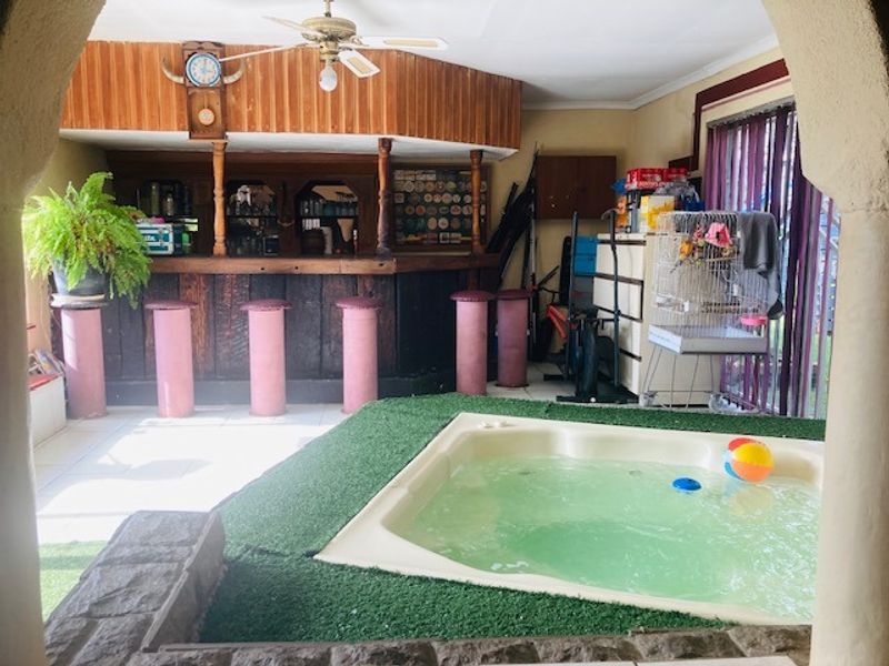 Indoor entertainment area featuring a built-in bar with counter seating and a sunken spa bath, offering a unique space for relaxation and social gatherings.