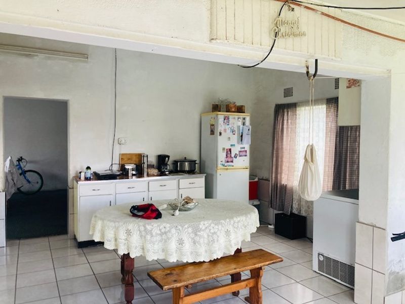 A dated kitchen area featuring tiled flooring and built-in cabinetry, offering potential for modernization and renovation.