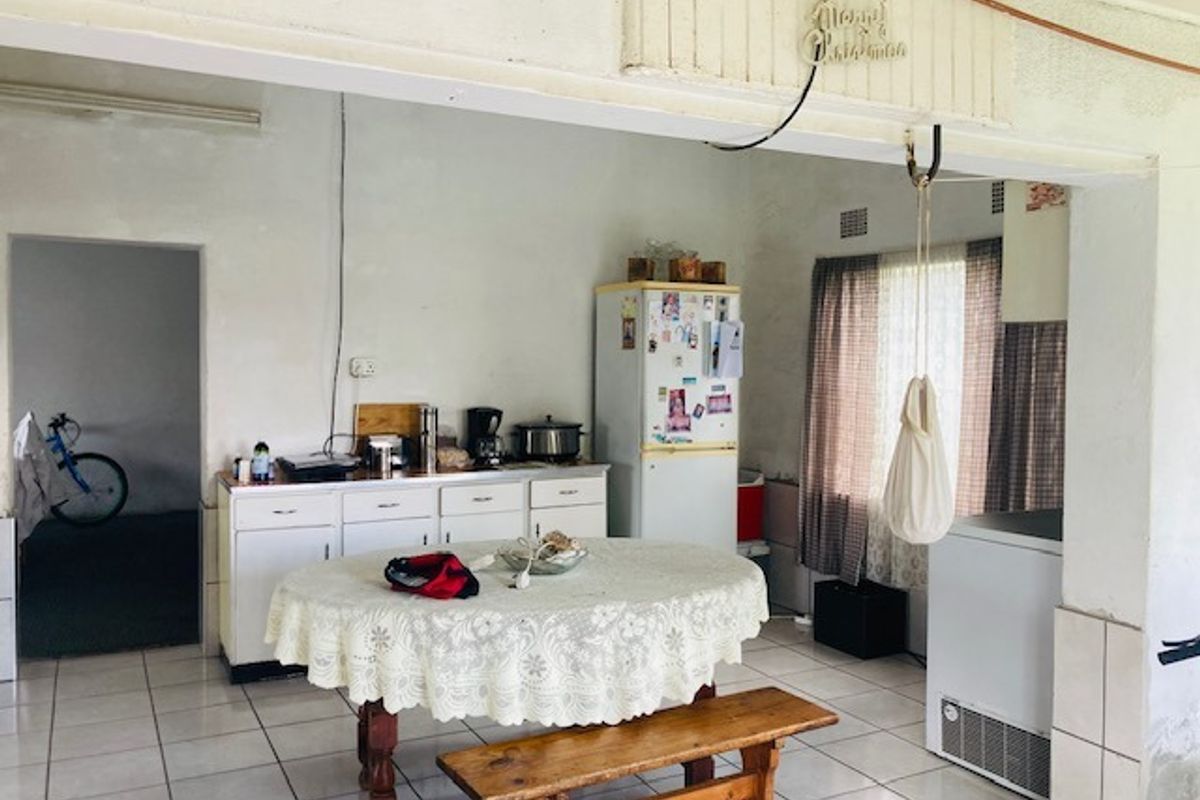 A dated kitchen area featuring tiled flooring and built-in cabinetry, offering potential for modernization and renovation.