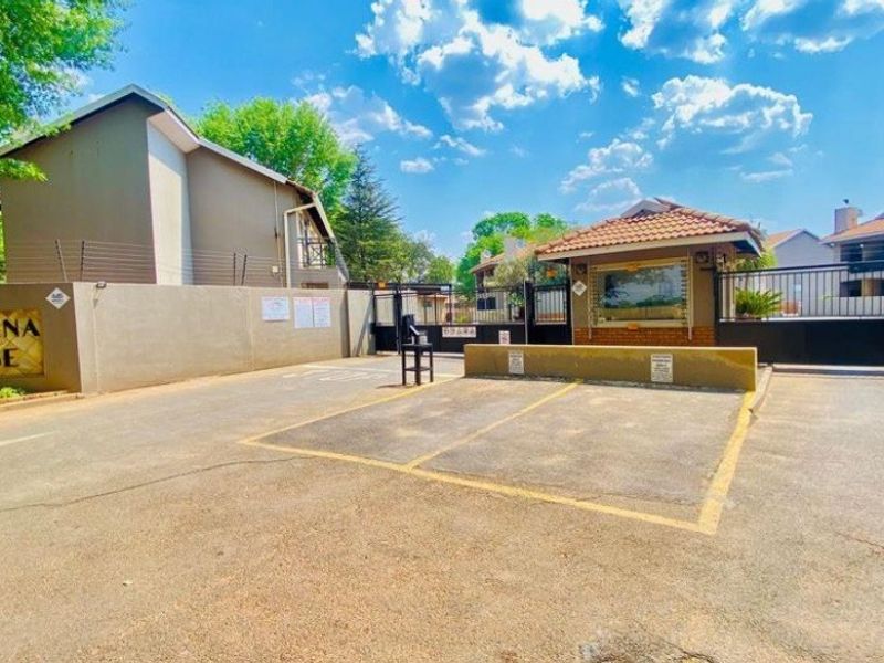 The entrance to Marsena Lodge featuring a secure gated access point, guard house, and paved driveway area.