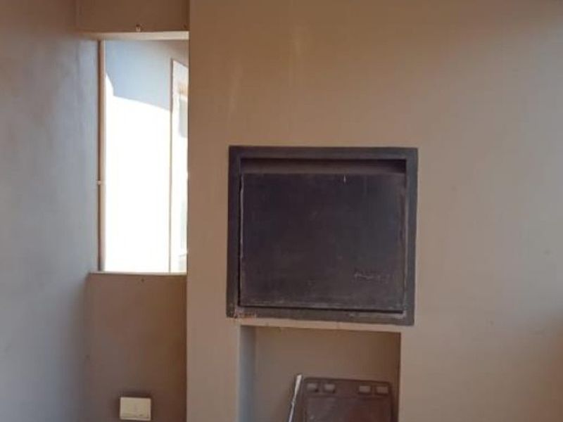 A balcony area featuring a built-in braai unit with unfinished wall surfaces, offering potential for outdoor entertainment space.