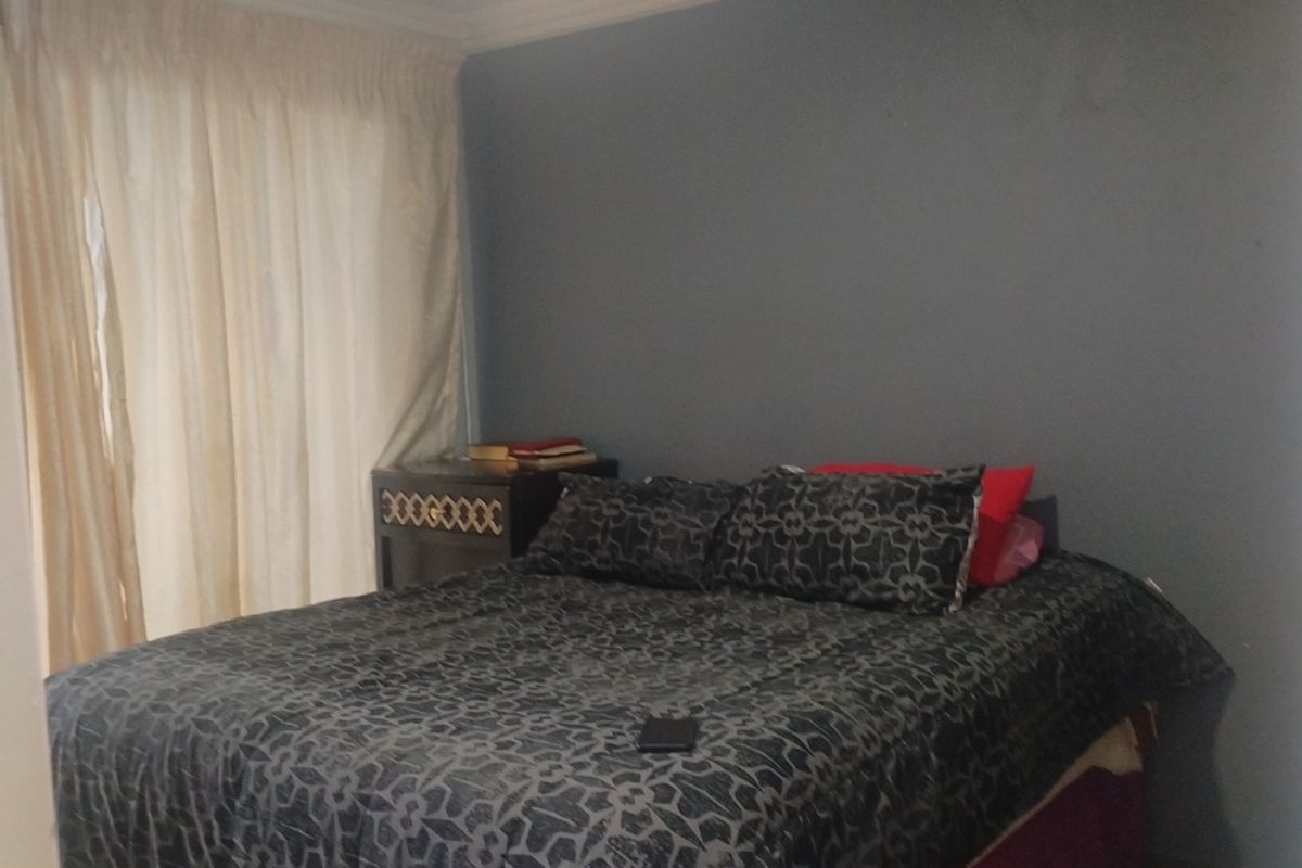 A standard bedroom featuring crown molding and neutral wall finishes, providing a functional space for rest.
