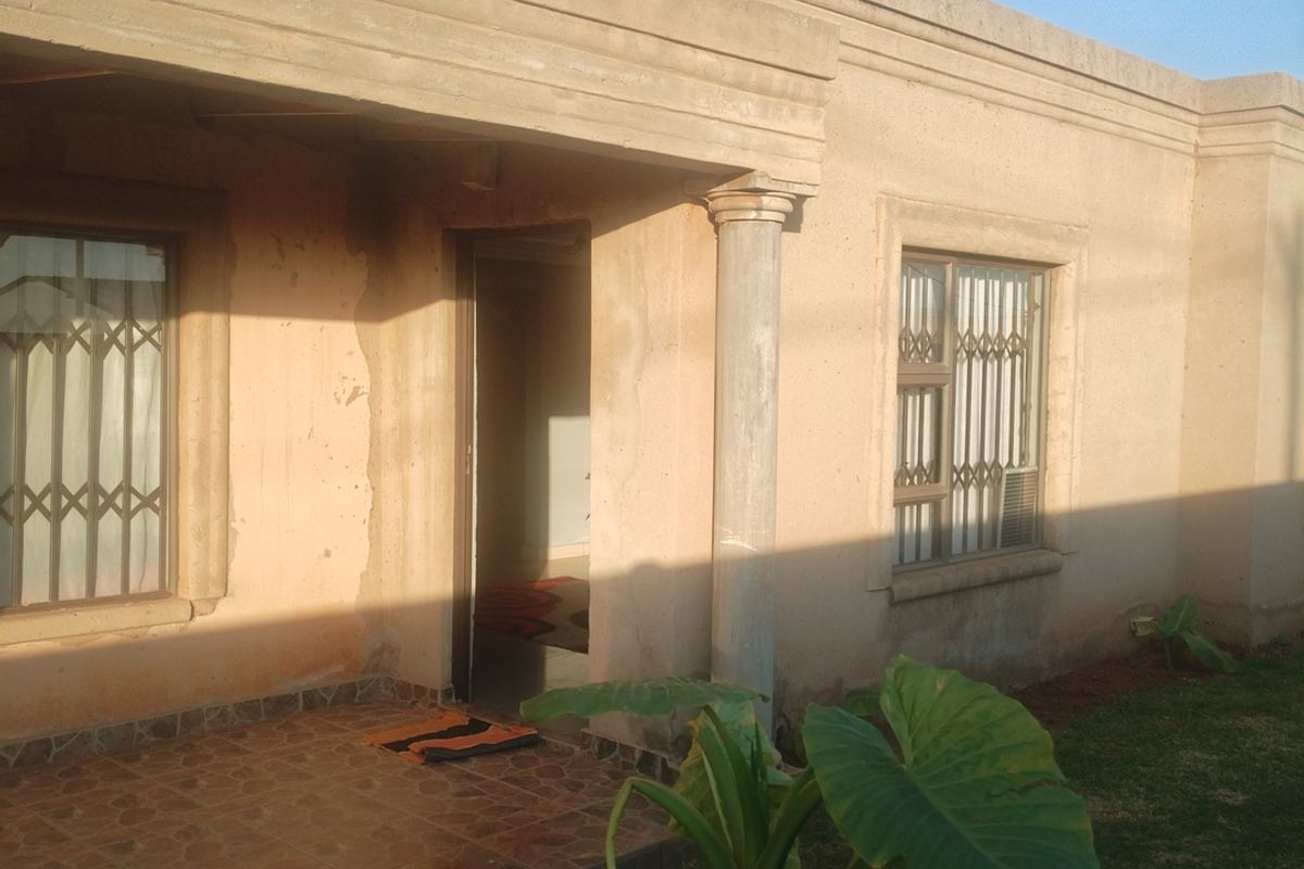 Front facade of a single-story house featuring a tiled entrance patio, security gates on windows, and concrete columns.