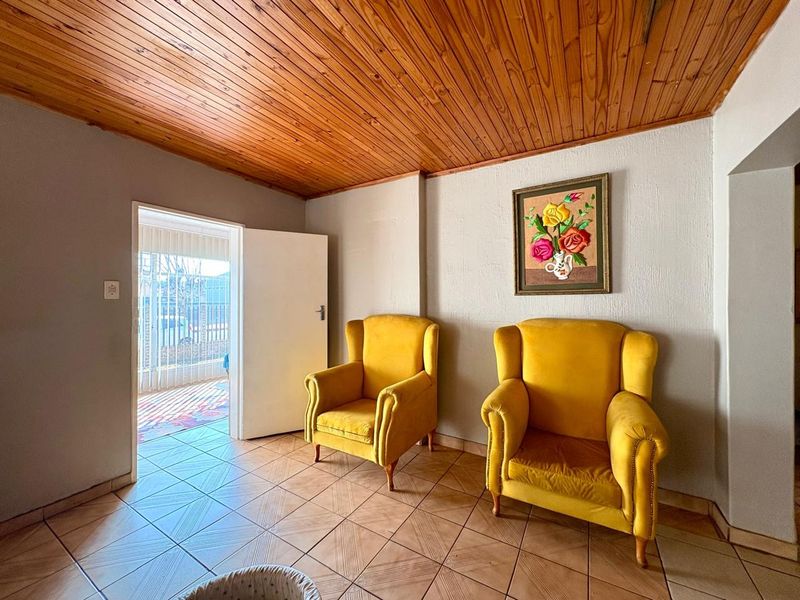 A living area featuring a timber tongue and groove ceiling and ceramic tiled flooring, providing direct access to an outdoor space.
