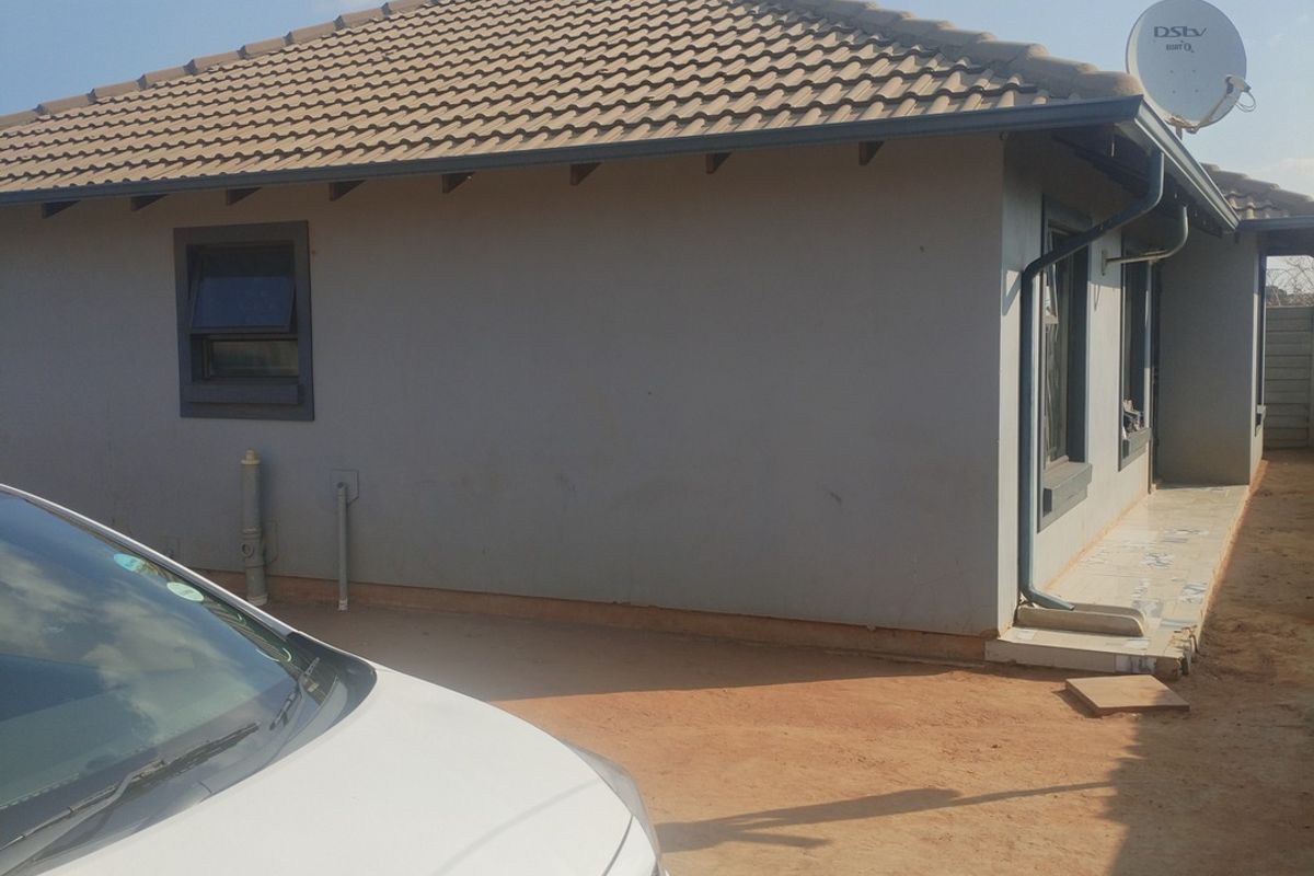 Rear exterior view of the house featuring a tiled roof, guttering system, and satellite dish installation.