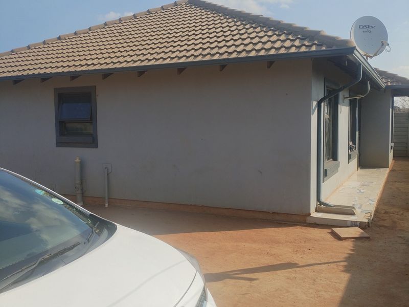 Rear exterior view of the house featuring a tiled roof, guttering system, and satellite dish installation.