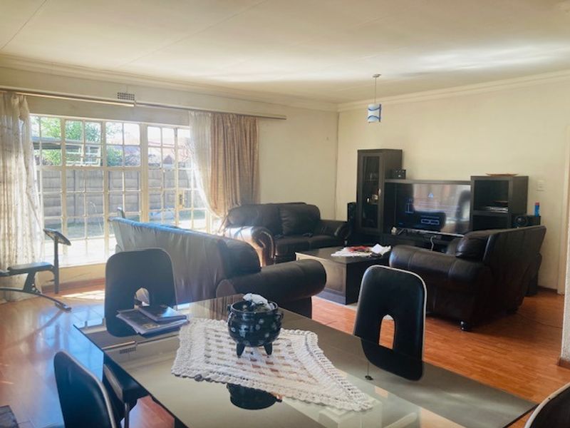 Spacious open-plan living and dining area featuring laminate flooring and large sliding glass doors providing natural light and access to the exterior.