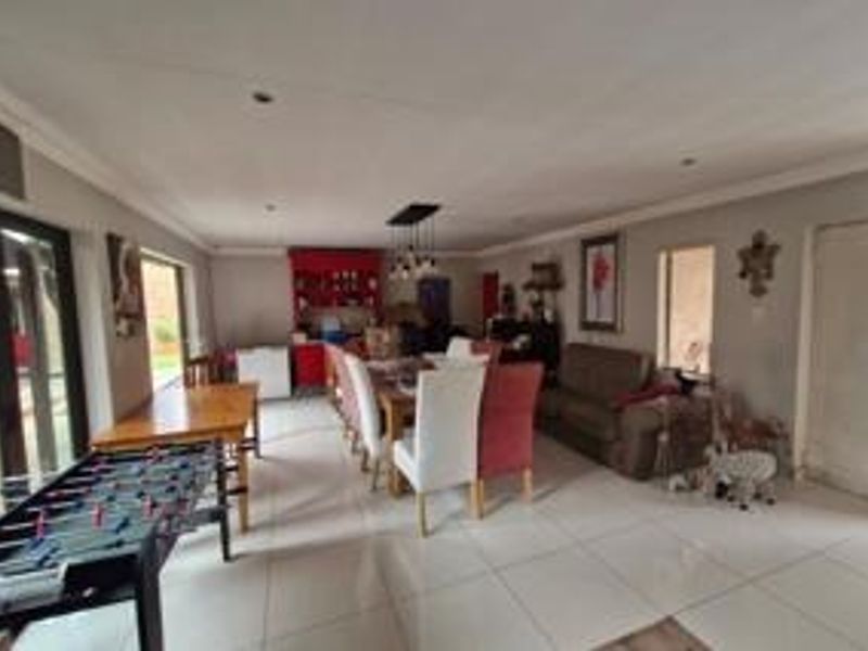 Spacious open-plan living and dining area featuring large format floor tiles, recessed lighting, and direct access to the outdoor patio through sliding glass doors.