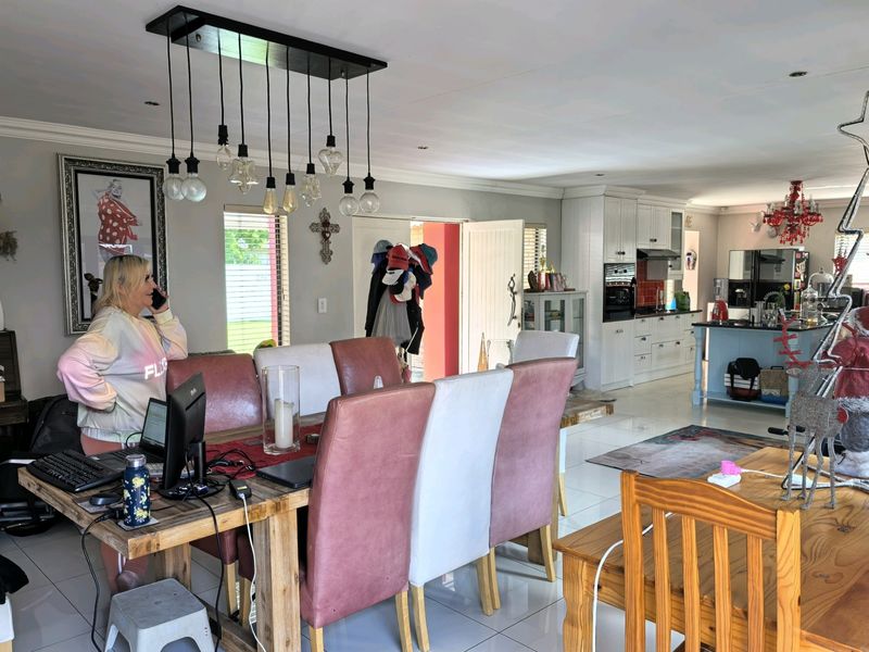 Spacious open-plan living and dining area featuring a modern kitchen with built-in cabinetry, a central island, and tiled flooring throughout.