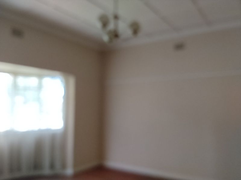 A vacant living room featuring traditional architectural details including a picture rail, coving, and a ceiling rose.