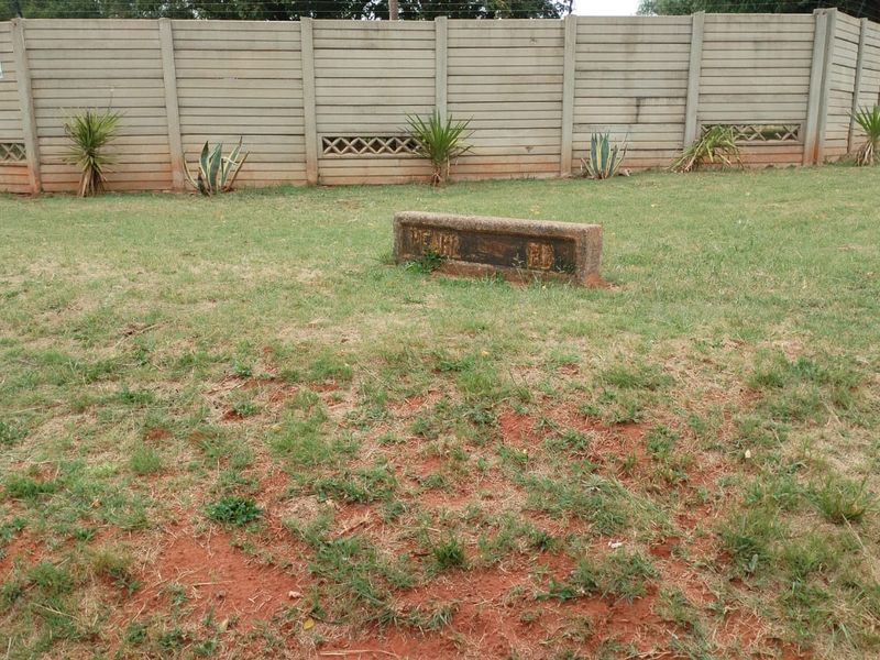 A view of the property garden featuring a secure precast concrete boundary wall and a small concrete signage plinth.