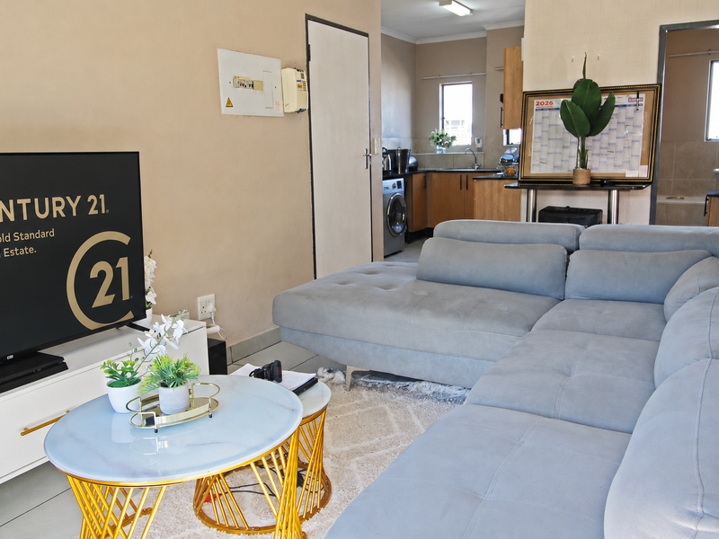 Open plan living area featuring a kitchen with built-in cabinetry and tiled flooring, seamlessly connected to the main living space.