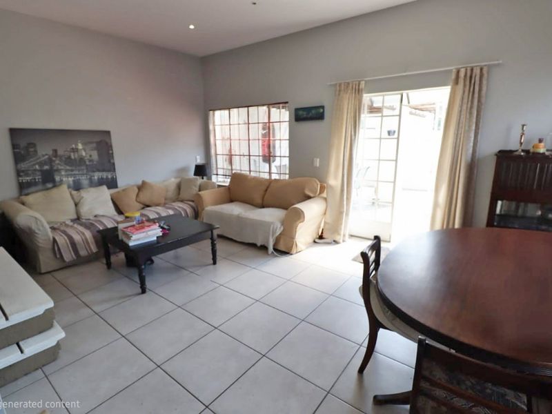 Open plan living and dining area featuring neutral tiled flooring, recessed lighting, and direct access to an outdoor space through a glass sliding door.