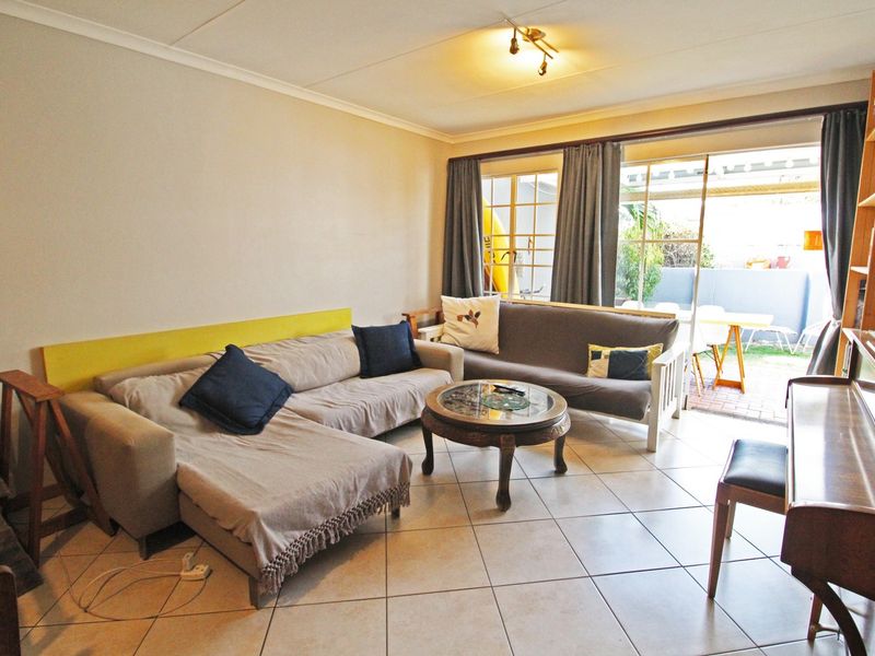 A living room featuring tiled flooring and sliding glass doors that provide access to an outdoor patio area.