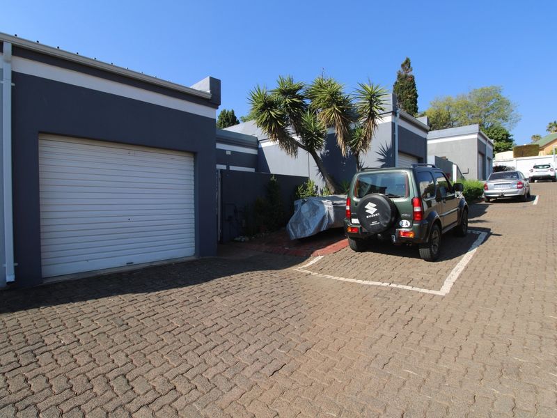 Exterior view of the apartment complex featuring a paved driveway and private garage access.