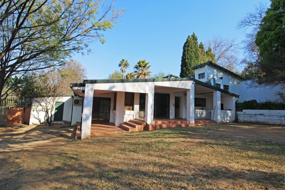 Rear view of the cottage featuring a covered patio area with tiled flooring, security gates, and direct access to the garden.
